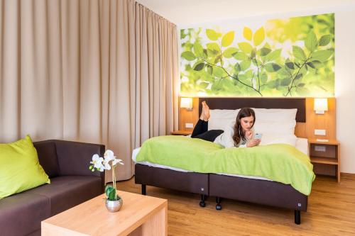 a woman laying on a bed in a hotel room at INhouse - Wohnen auf Zeit in Ingolstadt