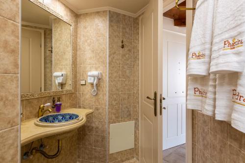 W łazience znajduje się umywalka i lustro. w obiekcie Phaedra Suites w Retimnie