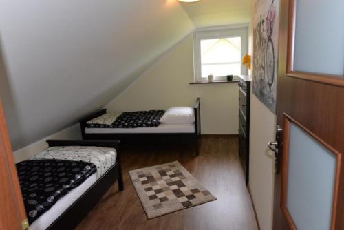 a attic room with two beds and a window at Apartament u Robsona in Wilkasy