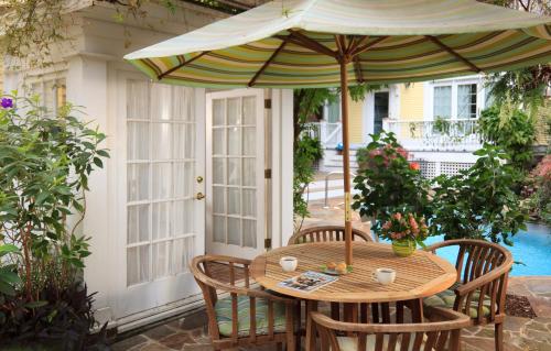 a wooden table with an umbrella on a patio at Azalea Inn and Villas in Savannah