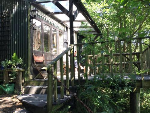 a wooden porch with a fence and a bench at Romany Wagon & Cwtch in Llandysul