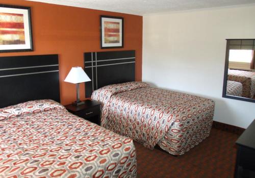 une chambre d'hôtel avec deux lits et une lampe dans l'établissement Woodlawn Hills Motel, à Henderson