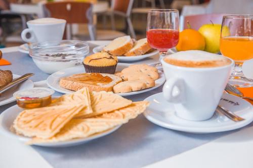 a table with plates of food and a cup of coffee at Hotel Prestige in Montesilvano