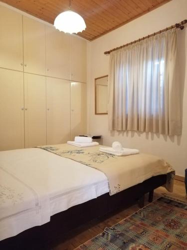 a bedroom with a large bed and a window at Lefki's house in Drymon