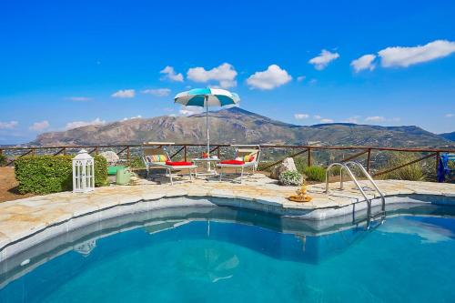 a pool with a table and chairs and an umbrella at Villa Delfino - Scopello-Villas in Scopello