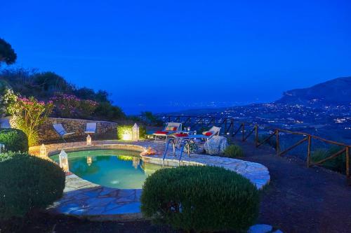 a swimming pool in the middle of a yard at night at Villa Delfino - Scopello-Villas in Scopello