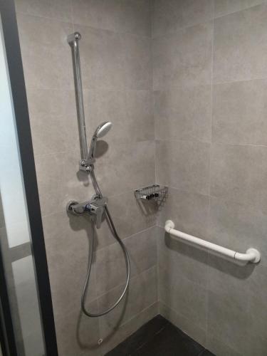a shower with a hose in a bathroom at MK STAY - formerly HOTEL MK in Hong Kong