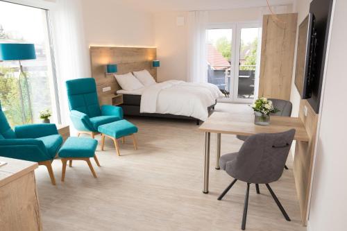 um quarto de hotel com uma cama, uma mesa e cadeiras em @home Boardinghouse em Dinklage