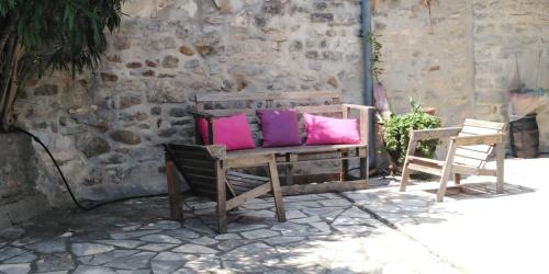 a bench with pink and purple pillows on it at les monteils in Grospierres