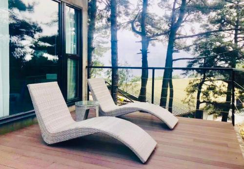 two white chairs sitting on top of a deck at Home of the Great Wall in Huairou