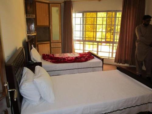 Heaven Dreams Guest House في Danna: غرفة فندقية بسريرين ونافذة