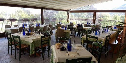 a restaurant with tables and chairs in a room at Hotel Ristorante Vittoria in San Fedele Intelvi