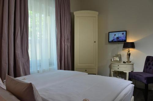 فندق دومسبيتزين في كولونيا: غرفه فندقيه بسرير ونافذه