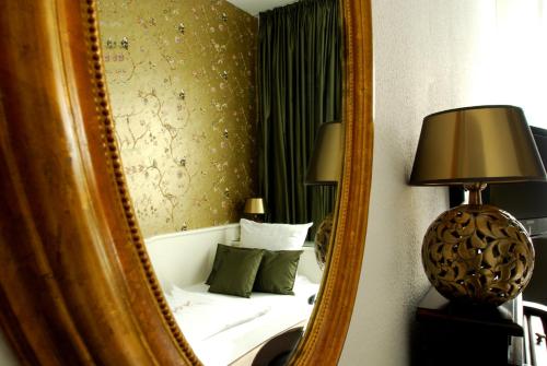 a mirror reflecting a bed in a hotel room at Hotel Domspitzen in Cologne