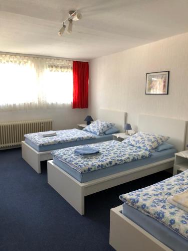 een kamer met drie bedden in een kamer bij Urberacher Hof in Rödermark