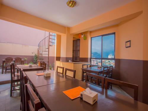 un ristorante con tavoli e sedie e una grande finestra di Hotel Premium a Kathmandu