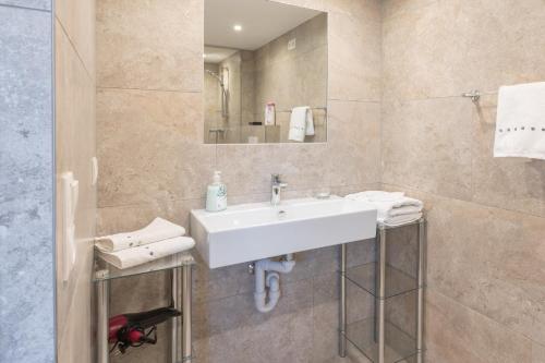 a bathroom with a white sink and a mirror at Ferienwohnung Metzler - Blick auf die Berge in Göfis
