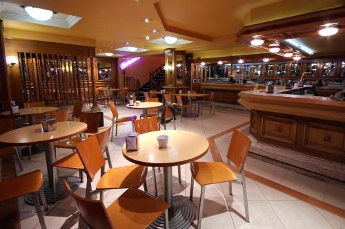 ポンテベドラにあるHotel City Express Comercioのテーブルと椅子のあるレストラン、バー