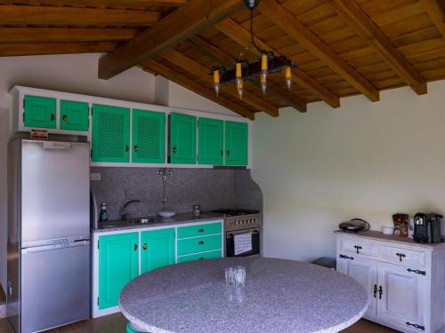 a kitchen with green cabinets and a table in it at Quintinha de Labrujó in Ponte de Lima