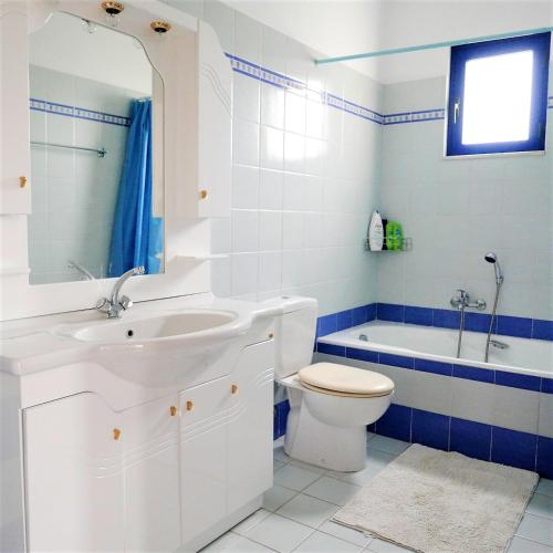a bathroom with a sink and a toilet and a tub at Electra Village House in Apolakkiá