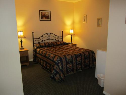 a hotel room with a bed and two lamps at Jade Mountain Motel in Chase