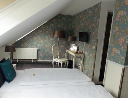 a bedroom with a bed and a desk and a chair at Hotel Domspitzen in Cologne