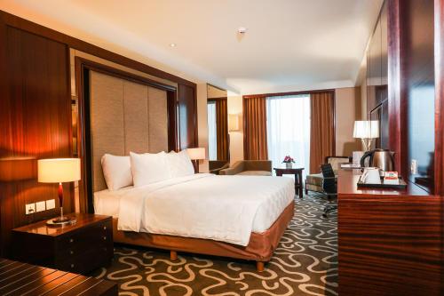une chambre d'hôtel avec un lit et un salon dans l'établissement Swiss-Belhotel Serpong, à Serpong
