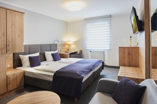 ein Hotelzimmer mit einem Bett und einem Stuhl in der Unterkunft Hotel Rose in Rüdesheim am Rhein