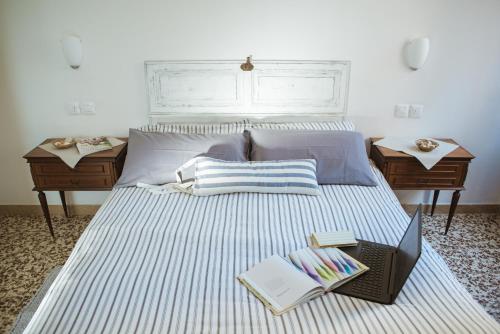 une chambre avec un lit avec deux tables et un livre dans l'établissement Riccione Beachouse, à Riccione