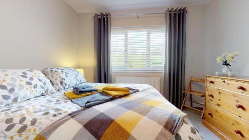 une chambre avec un lit, une commode et une fenêtre dans l'établissement Bracdy Cottage, à Llandyrnog