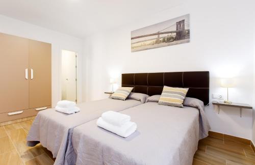 1 dormitorio con 2 camas y toallas blancas. en Armijorooms, en Nerja