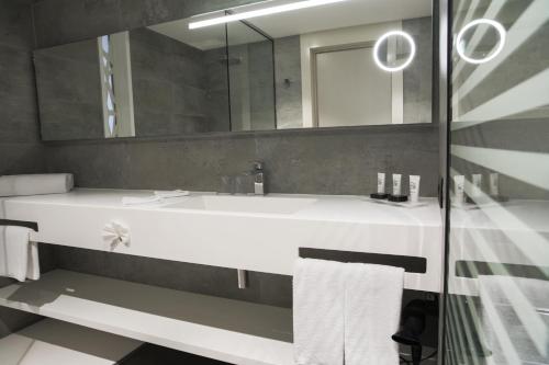 a bathroom with a white sink and a mirror at The Legacy Luxury Hotel, Algiers in Alger