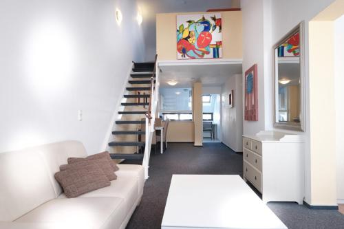 デュッセルドルフにあるアパートメントハウス アルト グラーツのリビングルーム(白いソファ、階段付)