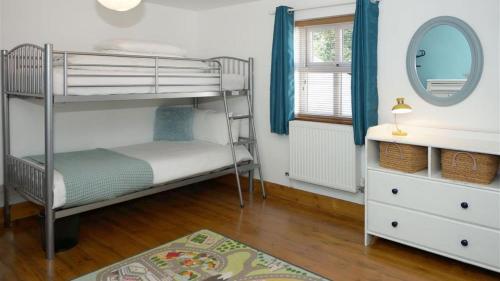 a bedroom with two bunk beds and a mirror at Llety'r Adar in Port Dinorwic
