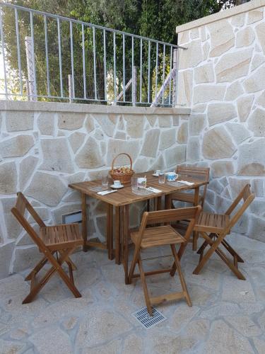 a wooden table and two chairs sitting next to a stone wall at Vivenda da Eva in Arcos de Valdevez