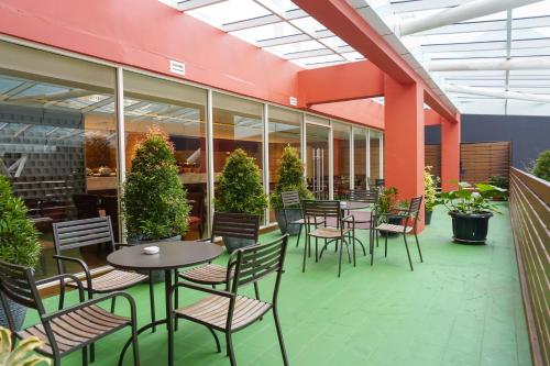 a patio with tables and chairs in a building at Swiss-Belhotel Serpong in Serpong