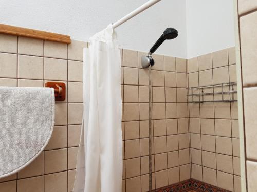 a shower with a white shower curtain in a bathroom at Casa de Abajo in Prado del Rey