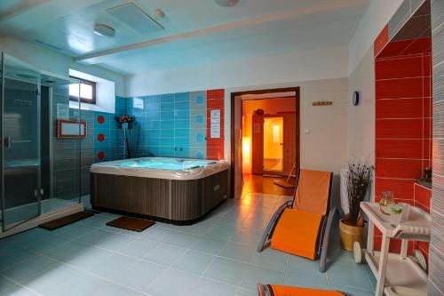 y baño grande con bañera y ducha. en Hotel Avalanche, en Štôla