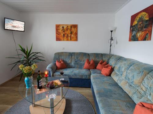 - un salon avec un canapé bleu et une table dans l'établissement Cosy holiday home with sauna in the Allg u, à Burggen