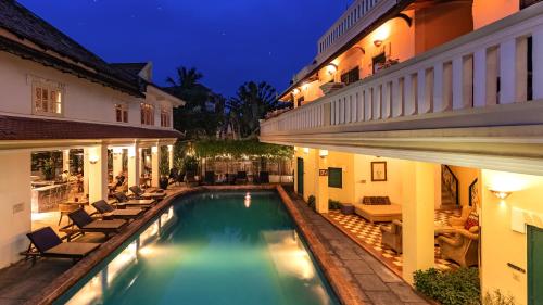 a pool in the courtyard of a house at night at Villa Wat Damnak in Siem Reap