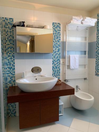 a bathroom with a sink and a mirror and a toilet at Hotel Villa Cittar in Novigrad Istria