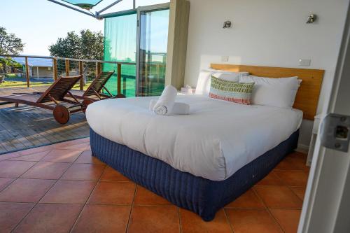 a bedroom with a large bed and a balcony at White Sands Estate in Falmouth