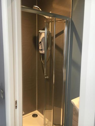 a shower with a glass door in a bathroom at Fort William Studios in Fort William