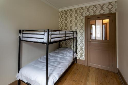a bedroom with two bunk beds and a door at Le Garage, Le Gite in Fontevraud-l'Abbaye