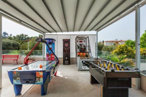 two billiards tables in a room with windows at Anna Hotel in Pefkohori