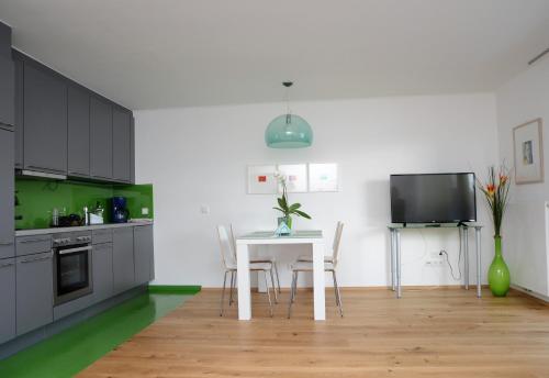 a kitchen with a table and chairs and a tv at Seeappartement Marina in Pörtschach am Wörthersee