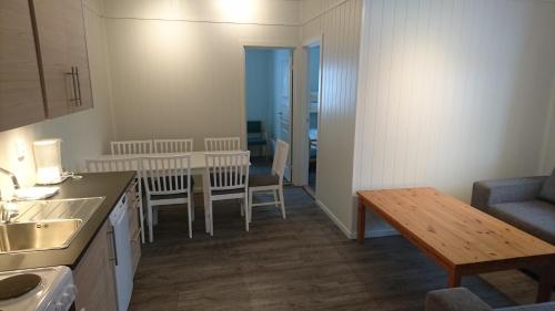 a kitchen with a table, chairs and a refrigerator at IMI Stølen in Oppdal