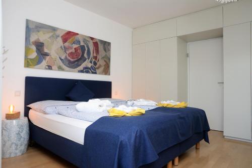 a bedroom with a blue bed with towels on it at Seeappartement Marina in Pörtschach am Wörthersee