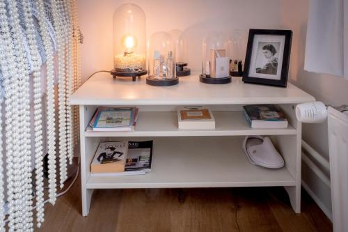 a white shelf with books and a lamp on it at Quartier Leonard in Ghent