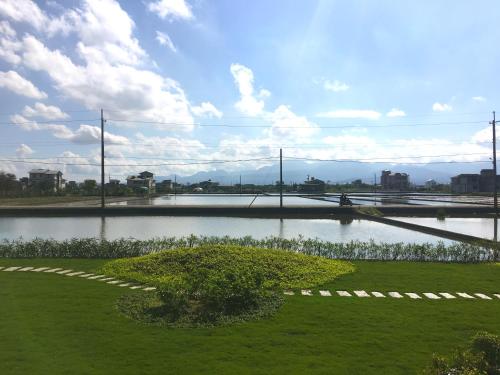 a body of water with a tree in the grass at Buluba in Yuanshan